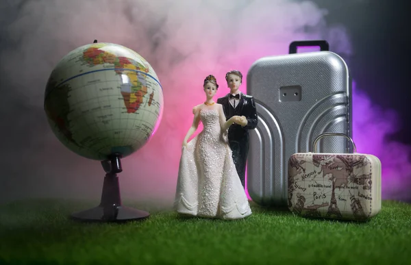 刚刚结婚的旅行概念 艺术品桌子装饰与夫妇附近的行李箱准备蜜月 深蓝色背景 选择性对焦 — 图库照片