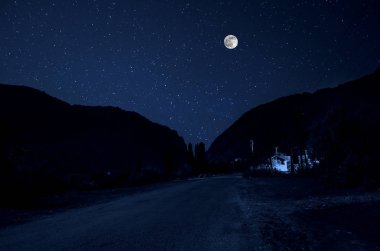 Dağ yolu ormandaki bir dolunay gecesi. Ülke yolun gece büyük moon ile doğal gece manzarası