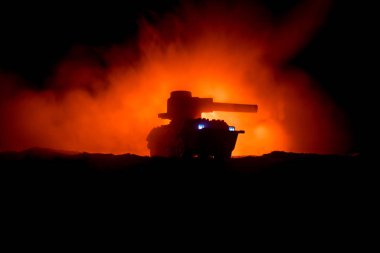 Savaş kavramı. Zırhlı Tank siluet aşağıda sisli yangın gökyüzü gece. Saldırı sahne. Oyuncak dekorasyon. Seçici odak