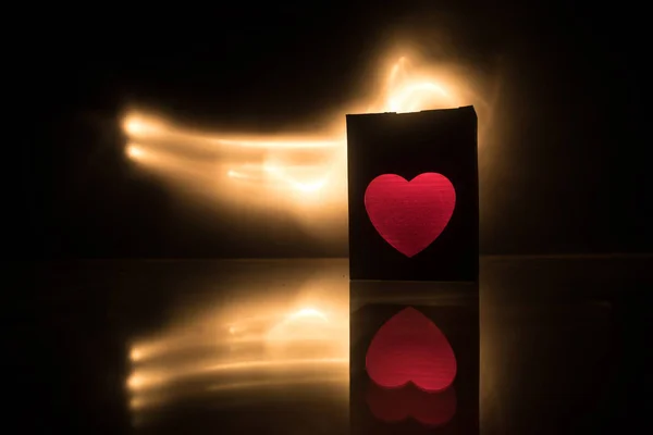 Dark table,Valentines day concept and love red shape heart with bokeh background, empty for text and placing products with copy space. Blurred glowing heart on a dark background with reflection