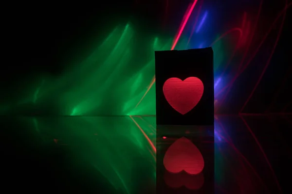 Dark table,Valentines day concept and love red shape heart with bokeh background, empty for text and placing products with copy space. Blurred glowing heart on a dark background with reflection