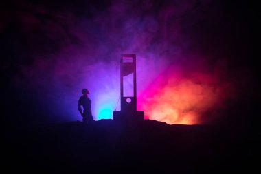 Horror view of Guillotine. Human at guillotine on a dark foggy background. Execution concept clipart