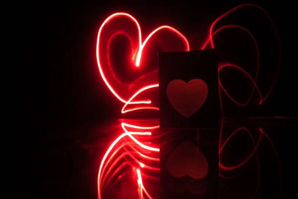 Dark table,Valentines day concept and love red shape heart with bokeh background, empty for text and placing products with copy space. Blurred glowing heart on a dark background with reflection