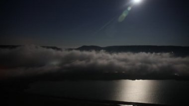 Ay ışığı ile derin gece timelapse bulutlar üzerinde uçan. Cennet üzerinde gece şehir ışıkları hareket ile uçuş. 