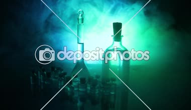 Eczane ve kimya teması. Araştırma laboratuarında çözeltisi olan cam deney şişesi. Bilim ve tıbbi geçmiş. Koyu renk arkaplan üzerinde laboratuvar test tüpleri, bilimsel araştırma ekipmanları konsepti