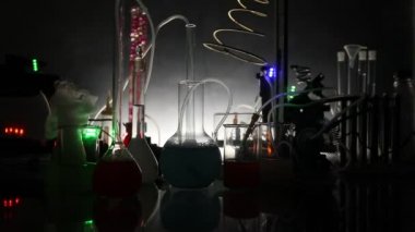 Eczane ve kimya teması. Araştırma laboratuarında çözeltisi olan cam deney şişesi. Bilim ve tıbbi geçmiş. Koyu renk arkaplan üzerinde laboratuvar test tüpleri, bilimsel araştırma ekipmanları konsepti