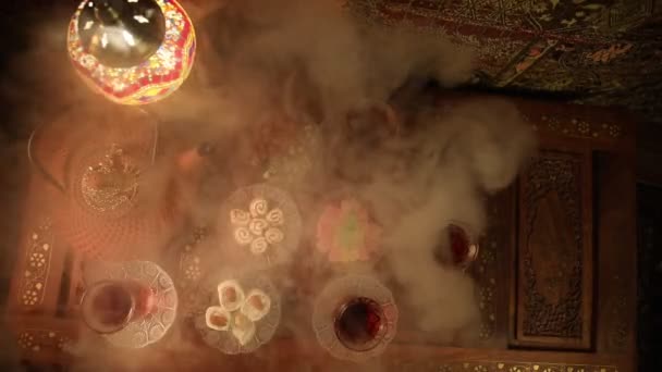 阿拉伯茶在玻璃与东方小吃在老式的木制表面 东方茶的概念 低浅色的休息室内饰 配有地毯 空的空间 选择性对焦 — 图库视频影像