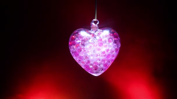 バレンタインの日の概念 暗闇の中 ガラスの心は輝く ガラス絵 黒の背景のガラスの透明な心 テキストの空スペース — ストック動画