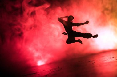 Karate sporcular sahne mücadele. Karakter karate. Şekil sanat dekorasyon poz. Spor Scramble veya karate ışık ile dekore edilmiş sisli arka plan üzerinde pratik adam.