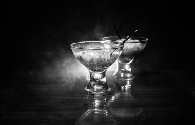 Cam tonda ışık ve sis ile koyu arka plan üzerinde renkli meyve dondurma dolu. Seçici odak