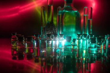 Eczane ve kimya teması. Araştırma laboratuarında çözeltisi olan cam deney şişesi. Bilim ve tıbbi geçmiş. Koyu renk arkaplan üzerinde laboratuvar test tüpleri, bilimsel araştırma ekipmanları konsepti