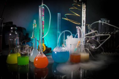 Eczane ve kimya teması. Araştırma laboratuarında çözeltisi olan cam deney şişesi. Bilim ve tıbbi geçmiş. Koyu renk arkaplan üzerinde laboratuvar test tüpleri, bilimsel araştırma ekipmanları konsepti