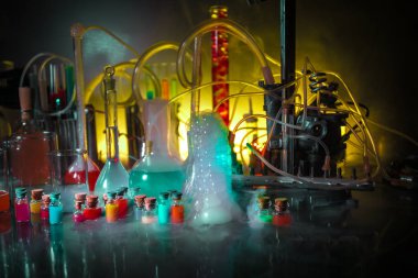 Eczane ve kimya teması. Araştırma laboratuarında çözeltisi olan cam deney şişesi. Bilim ve tıbbi geçmiş. Koyu renk arkaplan üzerinde laboratuvar test tüpleri, bilimsel araştırma ekipmanları konsepti