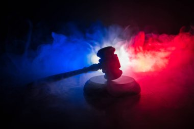 Hukuk tema, hakimin adalet heykeli ile ahşap masa üzerinde çekiç. Işık ile karanlık sisli zemin üzerine hukuk tokmak. Seçici odak