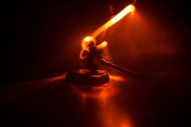 Hukuk tema, hakimin adalet heykeli ile ahşap masa üzerinde çekiç. Işık ile karanlık sisli zemin üzerine hukuk tokmak. Seçici odak