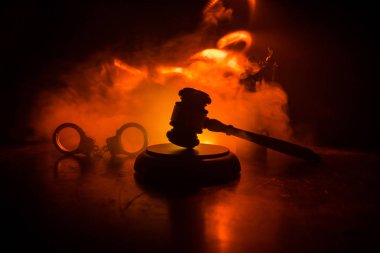 Hukuk tema, hakimin adalet heykeli ile ahşap masa üzerinde çekiç. Işık ile karanlık sisli zemin üzerine hukuk tokmak. Seçici odak