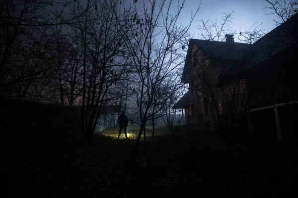 Geceleri ormanda bir hayaletin olduğu eski bir ev ya da sis içinde terk edilmiş bir korku evi. Ölü ağaç ormanındaki eski mistik bina. Geceleri aylı ağaçlar. Gerçeküstü ışıklar. Korku Cadılar Bayramı konsepti