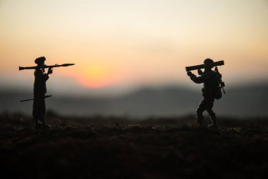 Askeri askerler bazuka ve roketatarlı siluetler. Savaş Konsepti. Askeri siluetler savaş sisli gökyüzü arka planında savaş sahnesi, RPG ile Mojahed ve güneş batarken bazukalı biz askerler. Saldırı sahnesi
