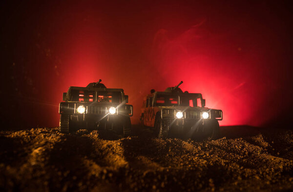 Концепция войны. Сцена сражения на фоне тумана войны, боевые силуэты под облачным горизонтом ночью. Армейский автомобиль с украшениями для солдат
