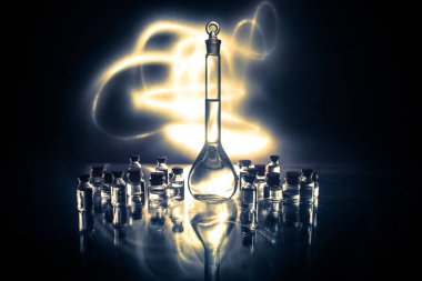 Eczane ve kimya teması. Araştırma laboratuarında çözeltisi olan cam deney şişesi. Bilim ve tıbbi geçmiş. Koyu renk arkaplan üzerinde laboratuvar test tüpleri, bilimsel araştırma ekipmanları konsepti