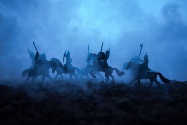 Süvari ve piyade ile ortaçağ savaş sahnesi. Siluetleri şekiller ayrı nesneler olarak mücadele günbatımı sisli arka plan savaşçılar arasında. Resim dekorasyon. Seçici odak