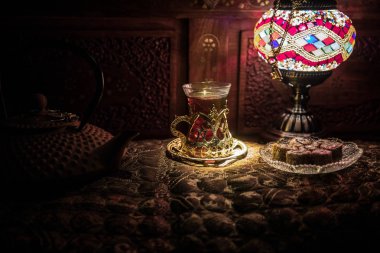 Arap çay Doğu vintage ahşap yüzey snacks ile cam. Doğu çay kavramı. Düşük ışık halı ile iç lounge. Boş alanı. Seçici odak.