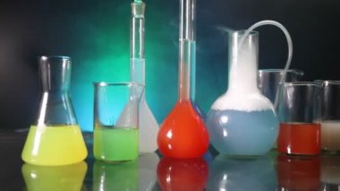 Eczane ve kimya teması. Araştırma laboratuarında çözeltisi olan cam deney şişesi. Bilim ve tıbbi geçmiş. Koyu renk arkaplan üzerinde laboratuvar test tüpleri, bilimsel araştırma ekipmanları konsepti