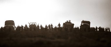 Düşman kavramı ile ele geçirdi. Askeri siluetleri ve kalabalığın üzerine savaş sis arka plan gökyüzü. Dünya Savaşı askerler ve korkmuş iken zırhlı araçlar hareketi izlerken insanlar. Resim dekorasyon. Seçici odak