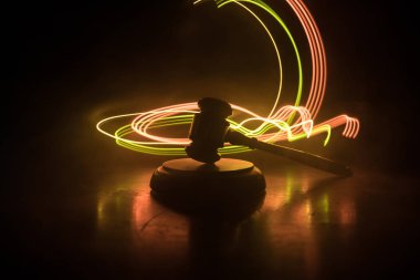 Hukuk tema, hakimin adalet heykeli ile ahşap masa üzerinde çekiç. Işık ile karanlık sisli zemin üzerine hukuk tokmak. Seçici odak