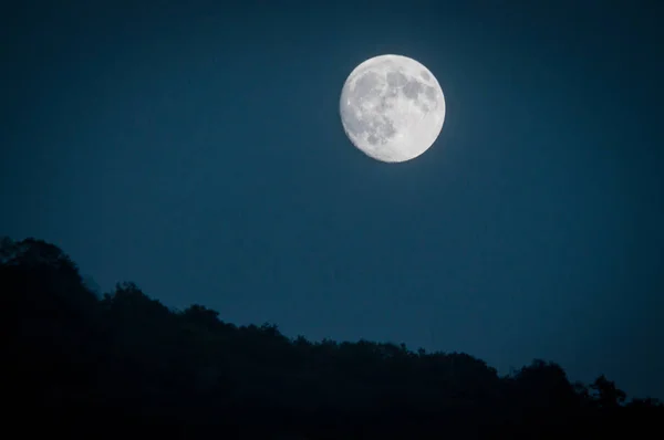深い青色の夜の空と遠くの層状丘劇的な山月上昇 自然ショット — ストック写真