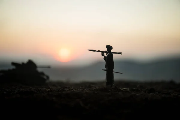 Military soldier silhouette with bazooka. War Concept. Military silhouettes fighting scene on war fog sky background, Soldier Silhouette aiming to the target at sunset. Attack scene