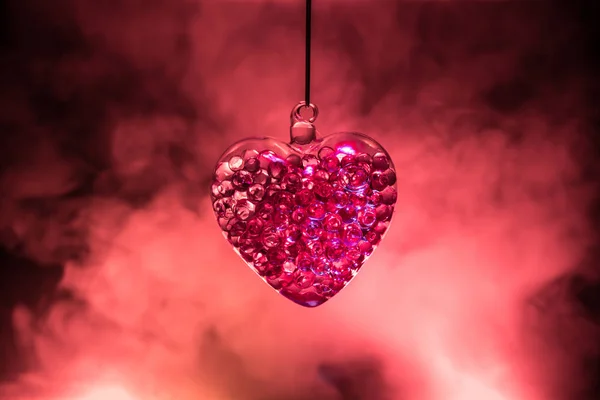 情人节概念 美丽的玻璃心脏在黑暗的雾蒙蒙的背景 透明的心 背后有浓烟和发光的光芒 为文本清空空间 — 图库照片