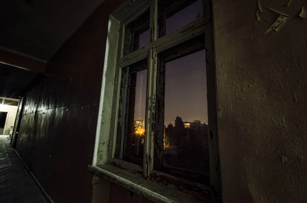 Dark corridor. Mystical interior of dark empty corridor, tunnel in an abandoned house. Old window at night. The interior of an abandoned house, road to hell. An old abandoned building