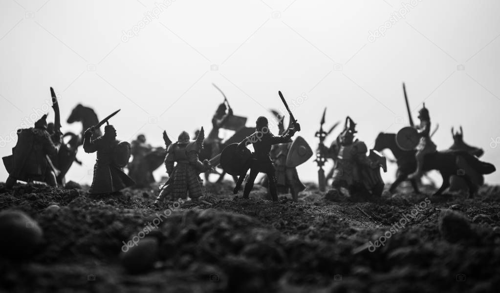 Medieval battle scene with cavalry and infantry. Silhouettes of figures as separate objects, fight between warriors on sunset foggy background. Artwork decoration. Selective focus