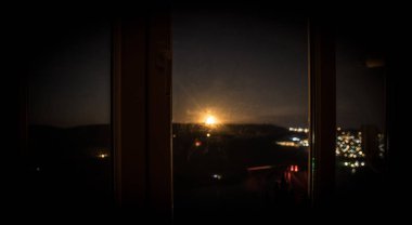 Gece sahne ayın karanlık oda gelen pencereden gördüm. Gece gökyüzü karanlık odada eski vintage fenerle penceresinden ile ilgilenen. Uzun pozlama vurdu