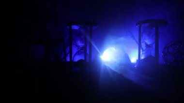Zaman kavramı. Kum bir kum saati için bir son tarih saymak aşağı olarak geçen süre ölçümünü cam ampuller geçiyor. Hourglasses Silhouette koyu arka plan üzerinde duman. Çiçeklerle