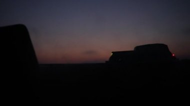 Eski model araba sisli karanlıkta parlayan ışıklar ile arka plan tonda siluet eski ışık yetersiz veya eski karanlık ormanın arabaya siluet. Seçici odak