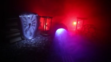 Zaman kavramı. Kum bir kum saati için bir son tarih saymak aşağı olarak geçen süre ölçümünü cam ampuller geçiyor. Hourglasses Silhouette koyu arka plan üzerinde duman. Çiçeklerle