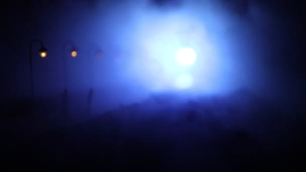 Gece yoğun sis içinde şehir. Kalın duman karanlık bir sokakta. Adam yolda siluetleri. Masa dekorasyonu. Seçici odak — Stok video