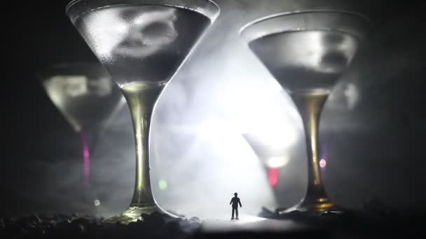 抽象酒精中毒的概念 一个人的剪影 站在一个雾蒙蒙的夜晚 巨大的眼镜充满了酒精饮料 站在路中间 创意艺术品装饰 — 图库视频影像