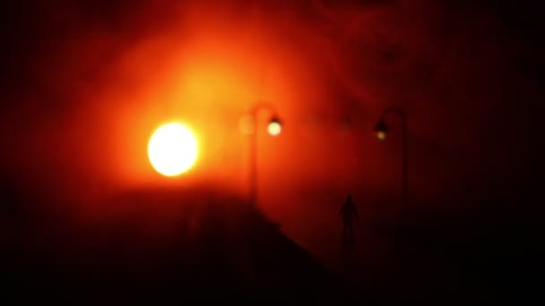 Ville la nuit dans un brouillard dense. Du smog épais dans une rue sombre. Des silhouettes d'homme sur la route. Décoration de table. Concentration sélective — Video