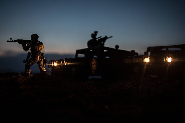 Концепция войны. Сцена сражения на фоне тумана войны, боевые силуэты под облачным горизонтом ночью. Армейский автомобиль с украшениями для солдат
