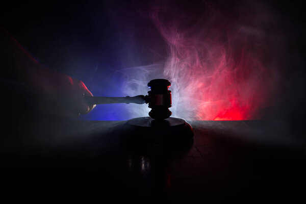 Law theme, mallet of the judge on wooden desk with Lady Justice Statue. Law gavel on dark foggy background with light. Selective focus