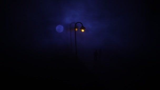 Città di notte nella fitta nebbia. Uno smog denso in una strada buia. Silhouette di uomo su strada. Decorazione tavola. Focus selettivo — Video Stock