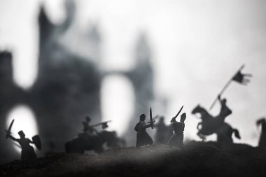 Süvari ve piyade ile ortaçağ savaş sahnesi. Siluetleri şekiller ayrı nesneler olarak mücadele günbatımı sisli arka plan savaşçılar arasında. Seçici odak