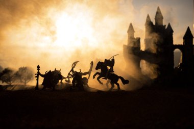 Süvari ve piyade ile ortaçağ savaş sahnesi. Siluetleri şekiller ayrı nesneler olarak mücadele günbatımı sisli arka plan savaşçılar arasında. Seçici odak