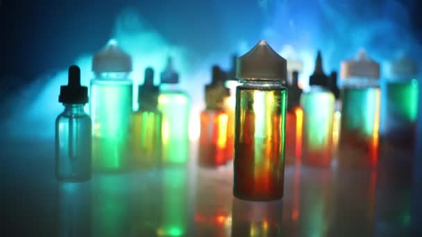 Electronic cigarette with vape liquids and christmas decorations on bokeh lights background — Stock Video