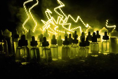 Vape kavramı. Duman bulutları ve vape sıvı şişe koyu arka plan üzerinde. Işık efektleri. Arka plan veya elektronik sigara reklam olarak kullanışlıdır. Seçici odak