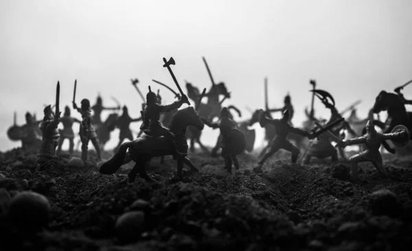 Medieval battle scene with cavalry and infantry. Silhouettes of figures as separate objects, fight between warriors on sunset foggy background. Artwork decoration. Selective focus