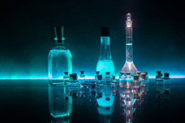 Eczane ve kimya teması. Araştırma laboratuarında çözeltisi olan cam deney şişesi. Bilim ve tıbbi geçmiş. Koyu renk arkaplan üzerinde laboratuvar test tüpleri, bilimsel araştırma ekipmanları konsepti